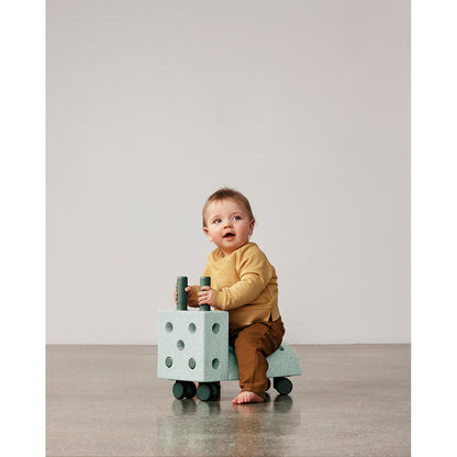 Baby sidder på Modu Tiny Ride aktivitetslegetøj i mint og grøn